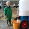 Young boy standing by milk mixer in farm